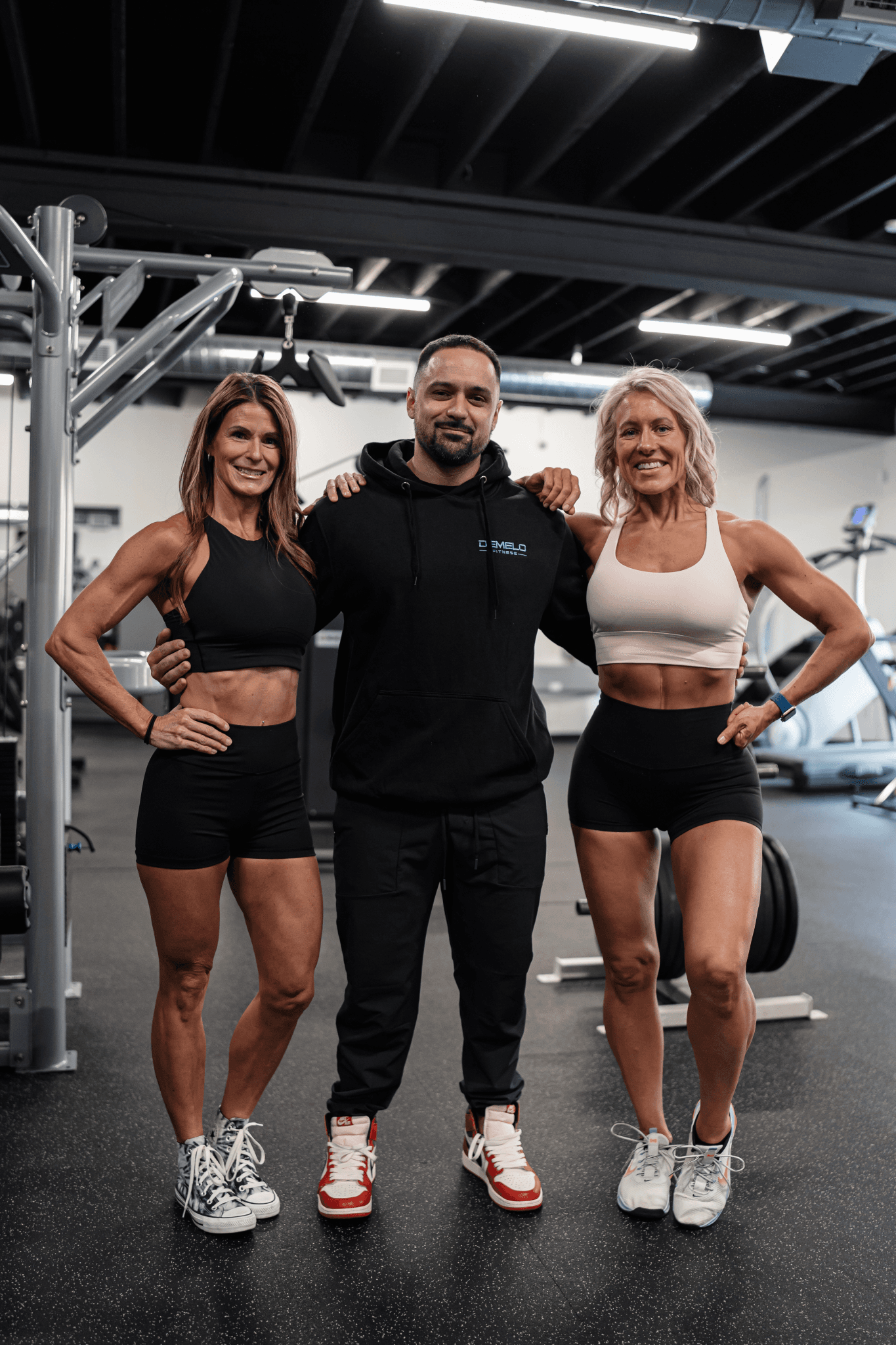 Josh DeMelo with two members on the training floor